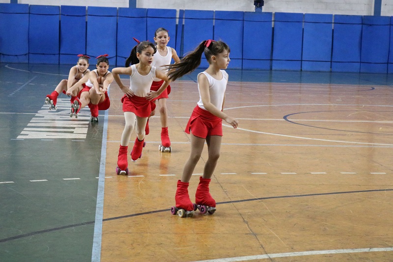 A patinação é uma modalidade esportiva que combina diversão, técnica e desenvolvimento físico em uma atividade dinâmica e estimulante. Muito procurada por crianças e adolescentes, a prática trabalha equilíbrio, coordenação motora e consciência corporal por meio de movimentos realizados sobre rodas. Além disso, a patinação promove condicionamento físico, disciplina e socialização em um ambiente seguro e motivador. Além disso, a prática da patinação melhora agilidade, postura corporal e resistência física. Durante as aulas, os alunos realizam exercícios de deslocamento, equilíbrio e controle corporal, fortalecendo musculatura e desenvolvendo maior estabilidade nos movimentos. Dessa forma, a modalidade contribui para desenvolvimento motor e aumento da confiança física. Outro grande benefício da patinação é o fortalecimento emocional e social. Ao aprender novas técnicas e superar desafios, os praticantes desenvolvem autoconfiança, concentração e perseverança. Ao mesmo tempo, as aulas incentivam convivência em grupo, respeito e interação social, criando experiências positivas e divertidas para os alunos. Da mesma maneira, a patinação pode ser praticada por diferentes níveis de experiência, desde iniciantes até alunos intermediários. Com acompanhamento especializado, cada praticante evolui gradualmente em técnicas, equilíbrio e segurança durante as atividades. Por fim, a patinação no Poliesportivo Unisanta oferece estrutura adequada e acompanhamento profissional para o desenvolvimento esportivo e recreativo dos alunos. Consequentemente, a prática regular da modalidade proporciona benefícios físicos, emocionais e sociais, promovendo saúde, qualidade de vida e muita diversão sobre rodas.
